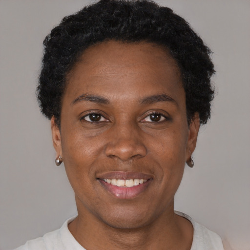 Joyful black young-adult female with short  black hair and brown eyes