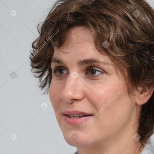 Joyful white adult female with medium  brown hair and green eyes