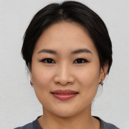 Joyful asian young-adult female with medium  black hair and brown eyes