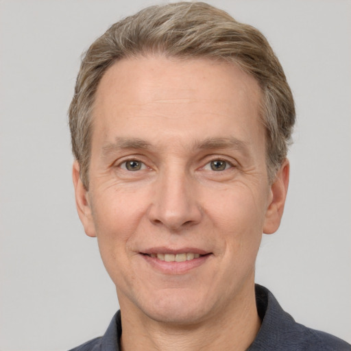 Joyful white adult male with short  brown hair and grey eyes