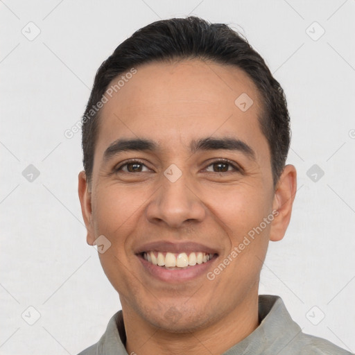 Joyful latino young-adult male with short  black hair and brown eyes