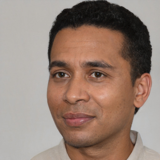 Joyful black young-adult male with short  black hair and brown eyes
