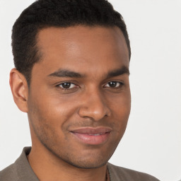 Joyful black young-adult male with short  brown hair and brown eyes