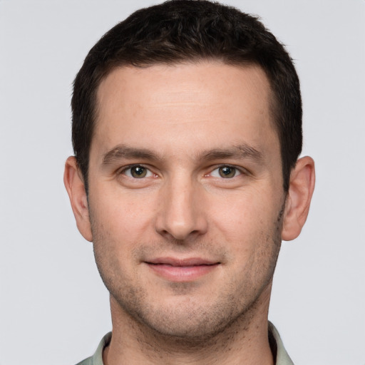 Joyful white young-adult male with short  brown hair and grey eyes