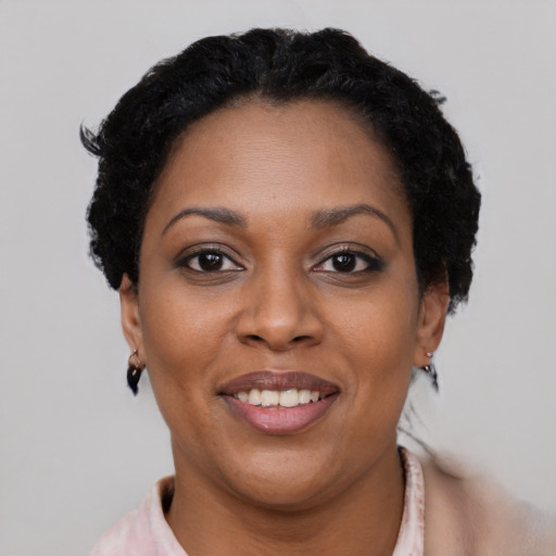 Joyful black adult female with short  brown hair and brown eyes
