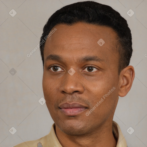 Joyful latino young-adult male with short  black hair and brown eyes