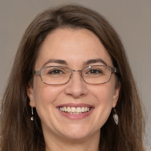 Joyful white adult female with long  brown hair and grey eyes