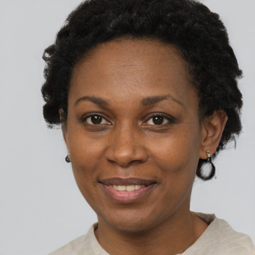 Joyful black adult female with short  black hair and brown eyes