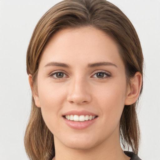 Joyful white young-adult female with long  brown hair and brown eyes