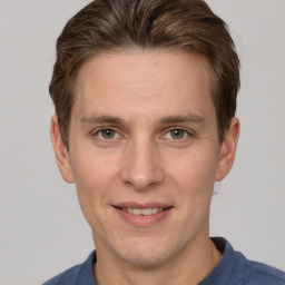 Joyful white adult male with short  brown hair and grey eyes