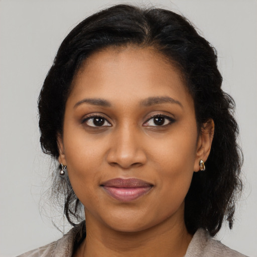 Joyful black young-adult female with long  black hair and brown eyes