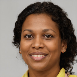 Joyful black adult female with long  brown hair and brown eyes