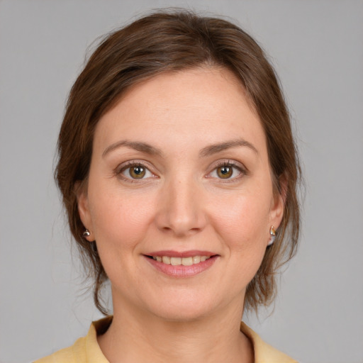 Joyful white young-adult female with medium  brown hair and grey eyes