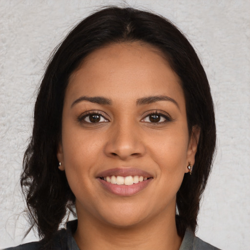 Joyful latino young-adult female with medium  brown hair and brown eyes