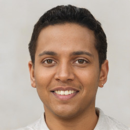 Joyful latino young-adult male with short  brown hair and brown eyes