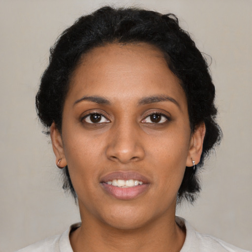 Joyful black young-adult female with short  black hair and brown eyes