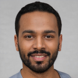 Joyful black young-adult male with short  black hair and brown eyes