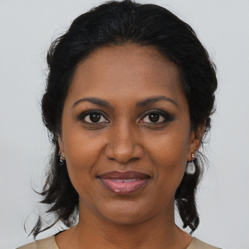 Joyful black adult female with medium  brown hair and brown eyes