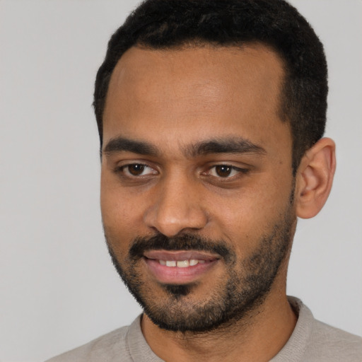 Joyful black young-adult male with short  black hair and brown eyes