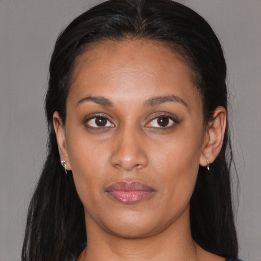 Joyful black young-adult female with long  brown hair and brown eyes