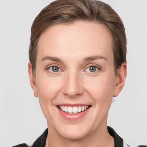 Joyful white young-adult female with short  brown hair and grey eyes