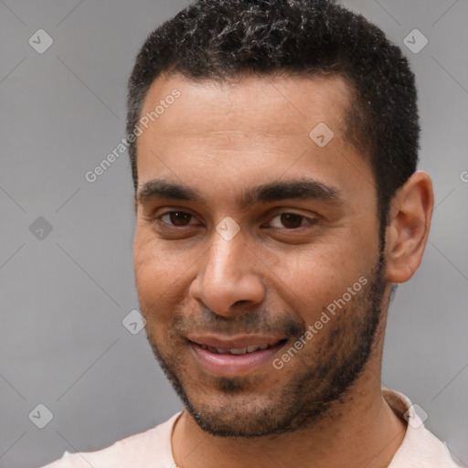 Joyful black young-adult male with short  brown hair and brown eyes