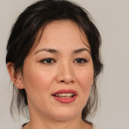 Joyful asian adult female with medium  brown hair and brown eyes