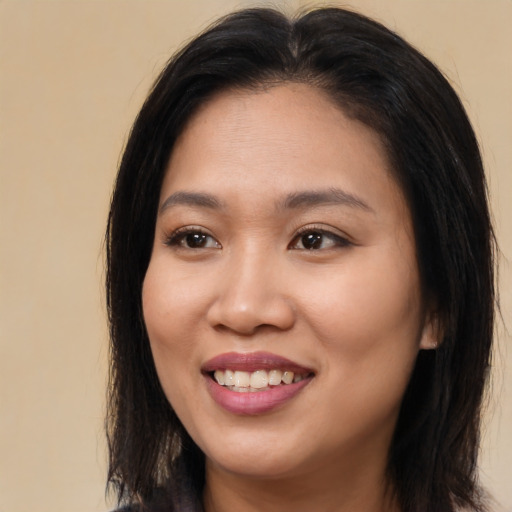 Joyful asian young-adult female with long  brown hair and brown eyes
