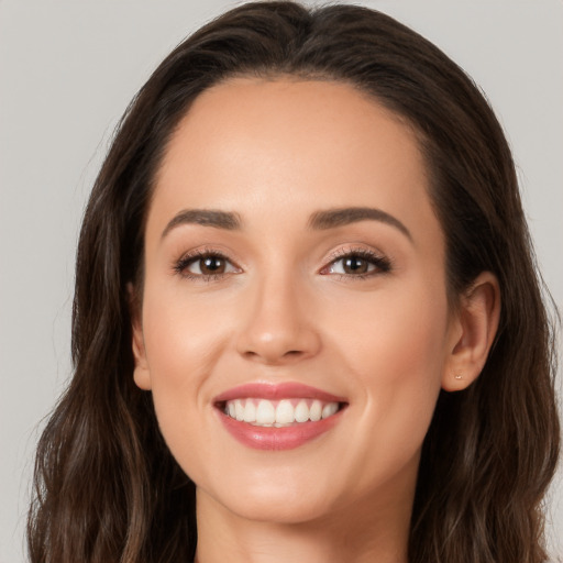 Joyful white young-adult female with long  brown hair and brown eyes