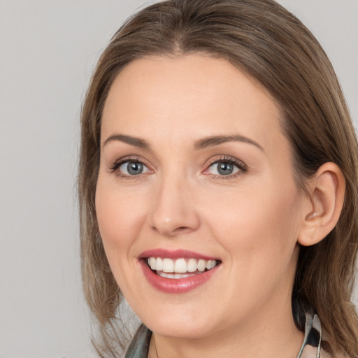 Joyful white young-adult female with medium  brown hair and grey eyes