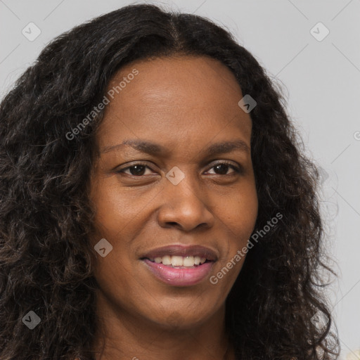 Joyful black young-adult female with long  brown hair and brown eyes