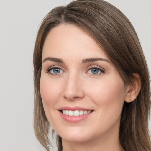 Joyful white young-adult female with long  brown hair and grey eyes