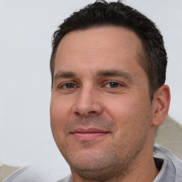 Joyful white adult male with short  brown hair and brown eyes