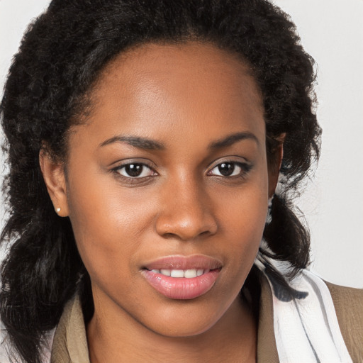 Joyful black young-adult female with long  brown hair and brown eyes