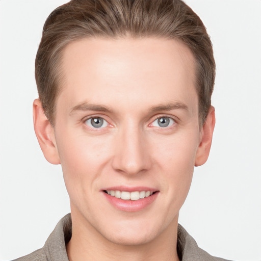 Joyful white young-adult male with short  brown hair and grey eyes