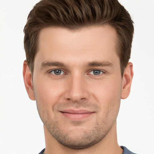 Joyful white young-adult male with short  brown hair and grey eyes