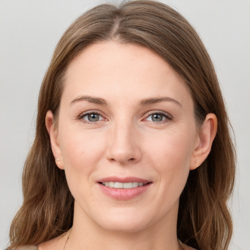 Joyful white young-adult female with medium  brown hair and grey eyes