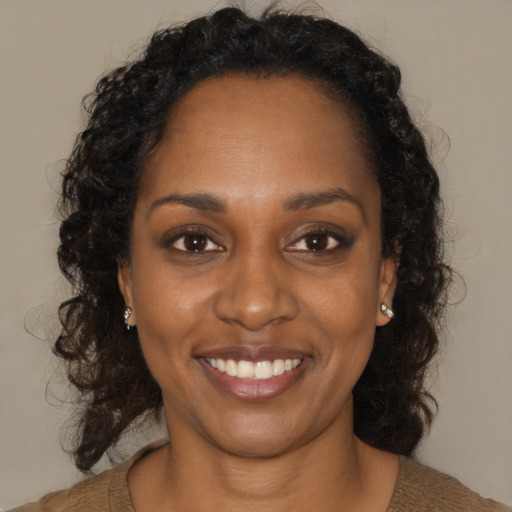 Joyful black young-adult female with medium  brown hair and brown eyes