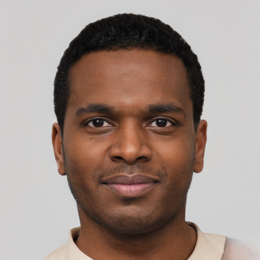 Joyful black young-adult male with short  black hair and brown eyes