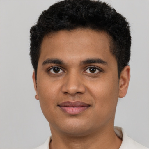Joyful latino young-adult male with short  brown hair and brown eyes