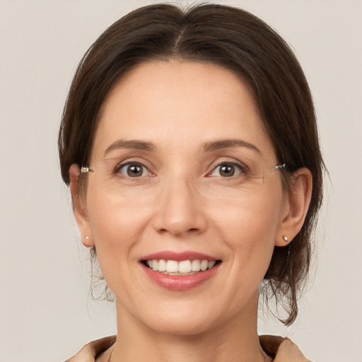 Joyful white young-adult female with medium  brown hair and grey eyes