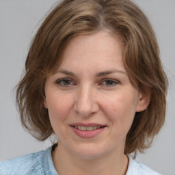 Joyful white adult female with medium  brown hair and blue eyes