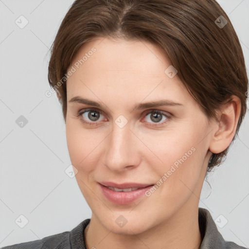 Joyful white young-adult female with short  brown hair and grey eyes