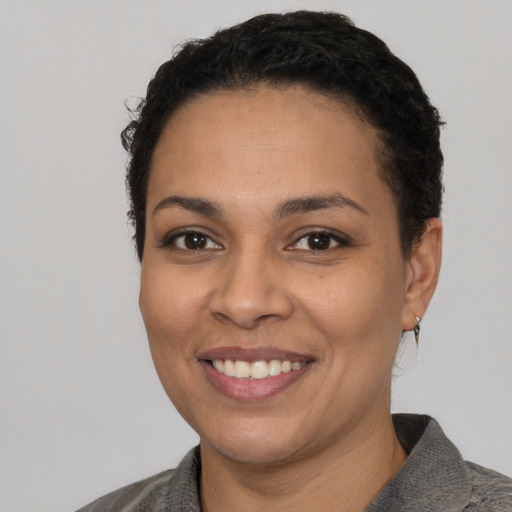 Joyful latino young-adult female with short  black hair and brown eyes