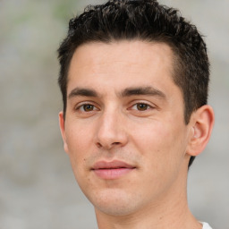 Joyful white young-adult male with short  black hair and brown eyes