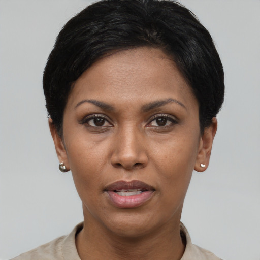 Joyful black young-adult female with short  black hair and brown eyes