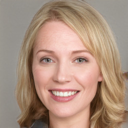 Joyful white young-adult female with medium  brown hair and blue eyes