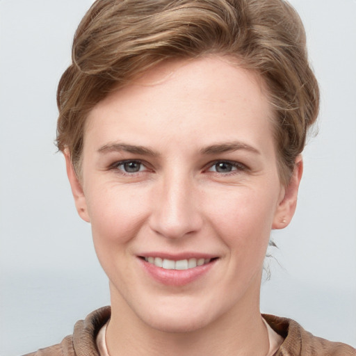 Joyful white young-adult female with short  brown hair and grey eyes