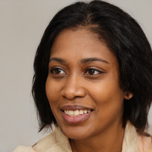 Joyful black young-adult female with medium  black hair and brown eyes