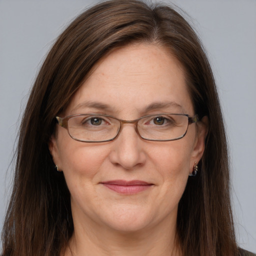 Joyful white adult female with long  brown hair and grey eyes